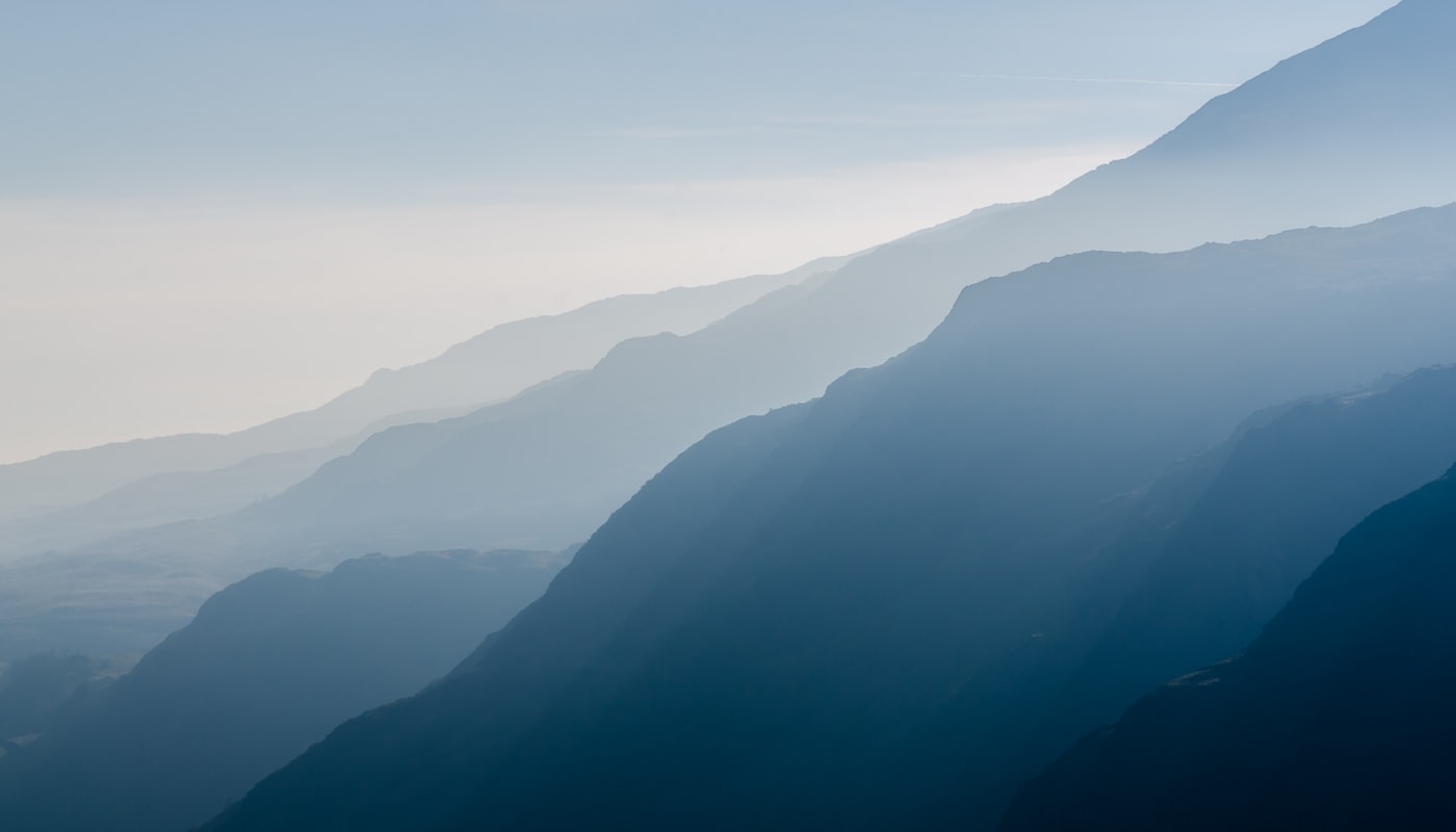 Black and white photograph of Swiss mountain ridges under a soft haze