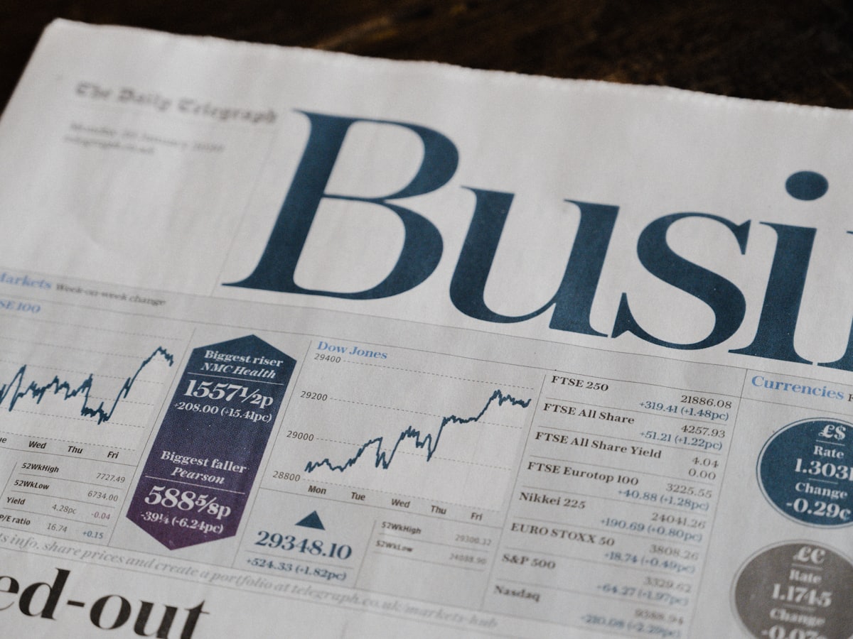 Black and white photograph of a business newspaper spread on a desk